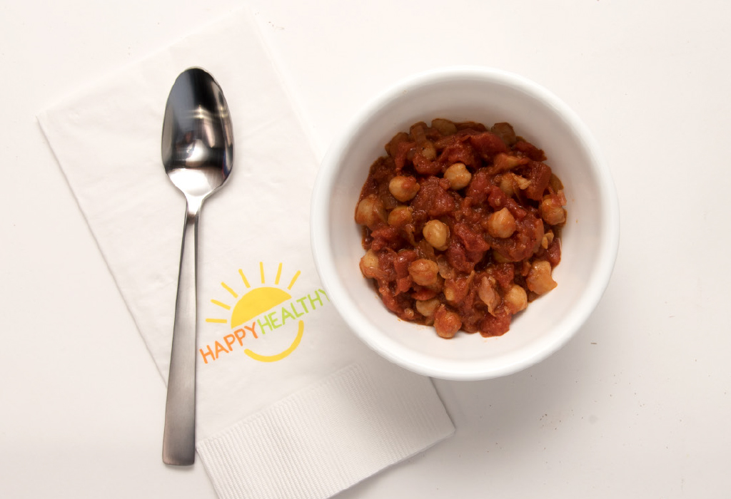  spoon, napkin, and bowl of chickpeas and tomatoes