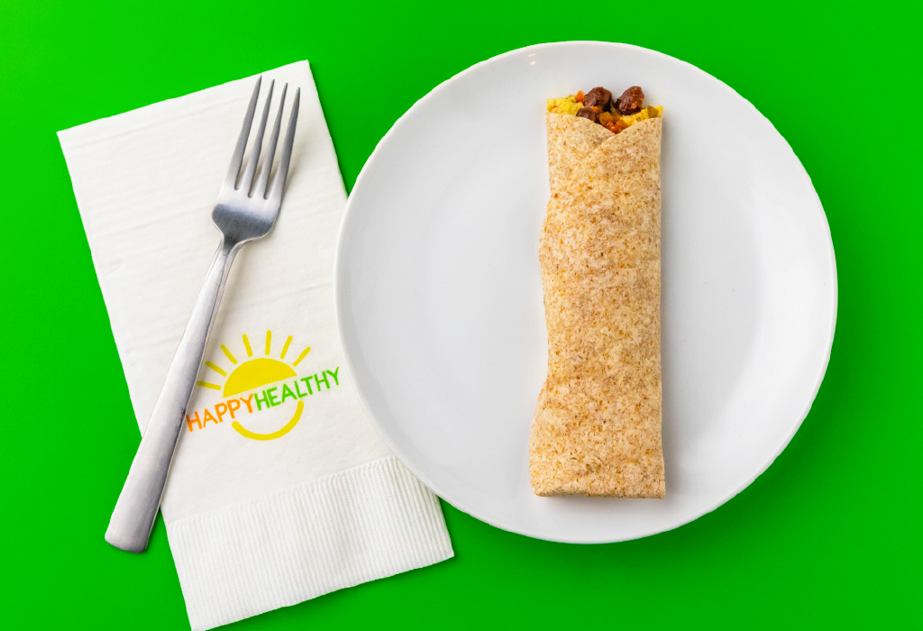Breakfast Burrito on white plate next to HappyHealthy napkin and fork