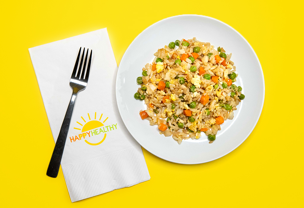 A plate of fried rice next to a fork and HappyHealthy napkin