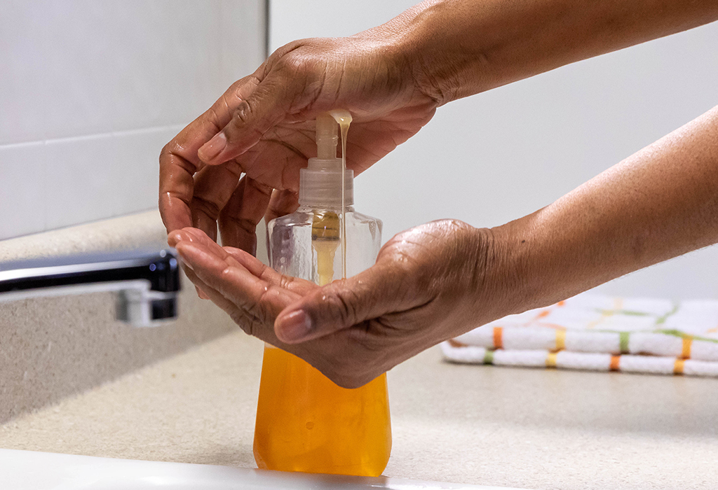 Hands pumping soap at a sink