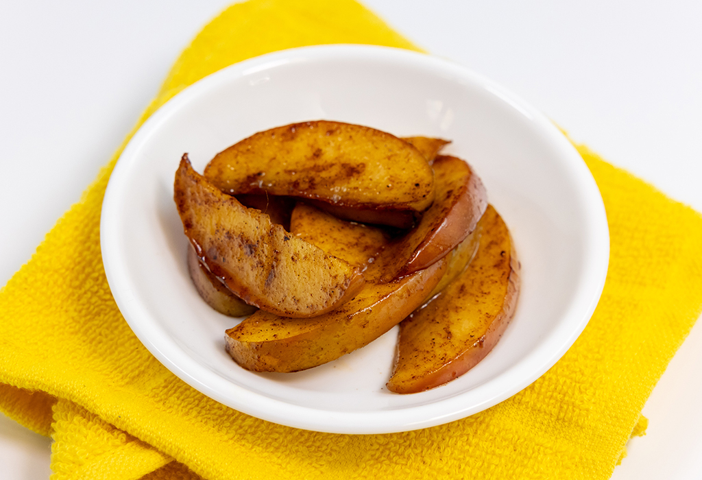 A bowl of Hot Cinnamon Apples on a yellow napkin