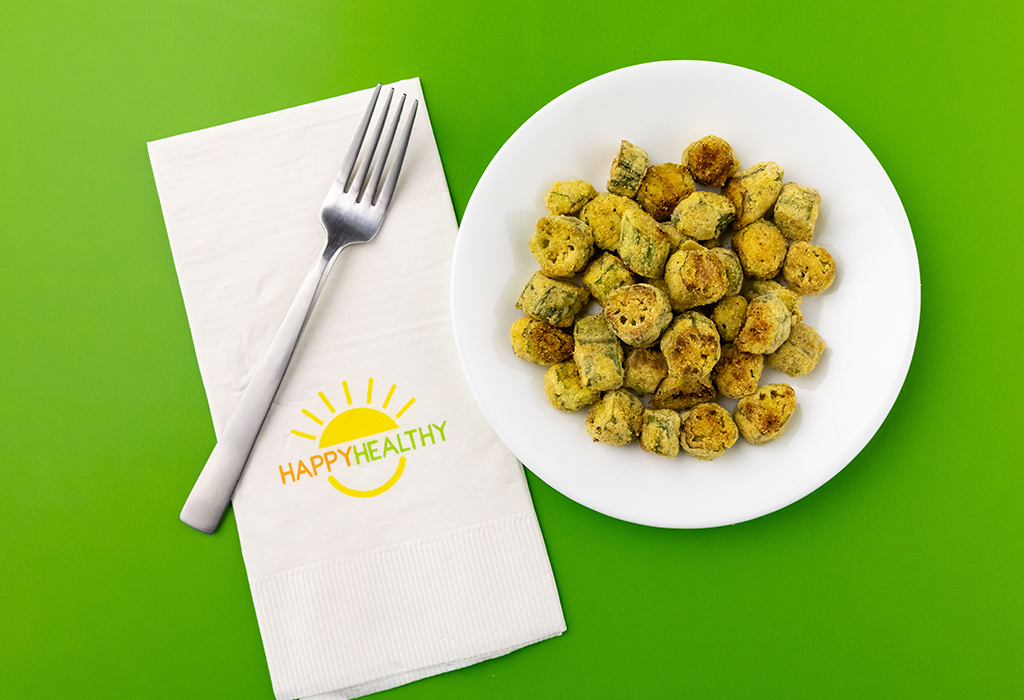 Fried okra bites on a white plate next to a HappyHealthy Napkin and Fork