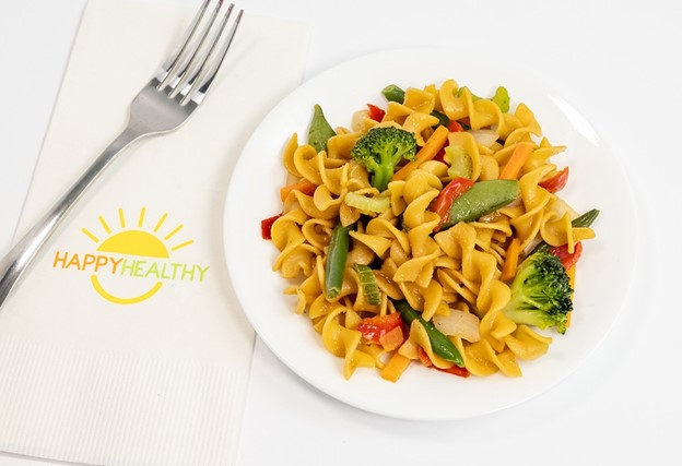 A plate of pasta with stir fried vegetables