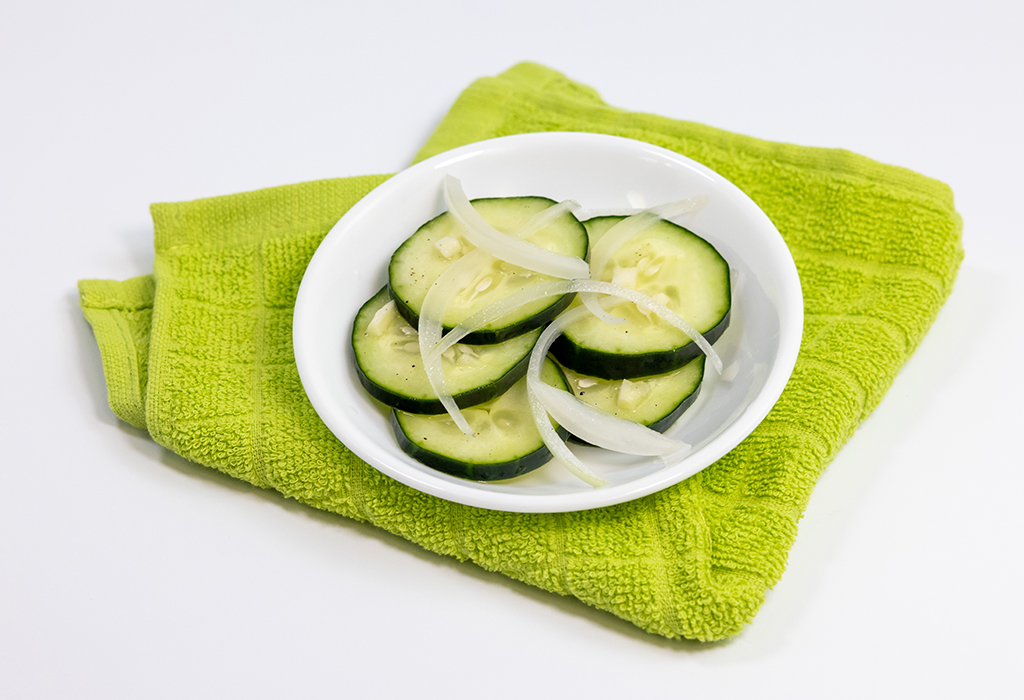 A pickle jar full of Quick-Pickle Cucumbers and Onions on a white background