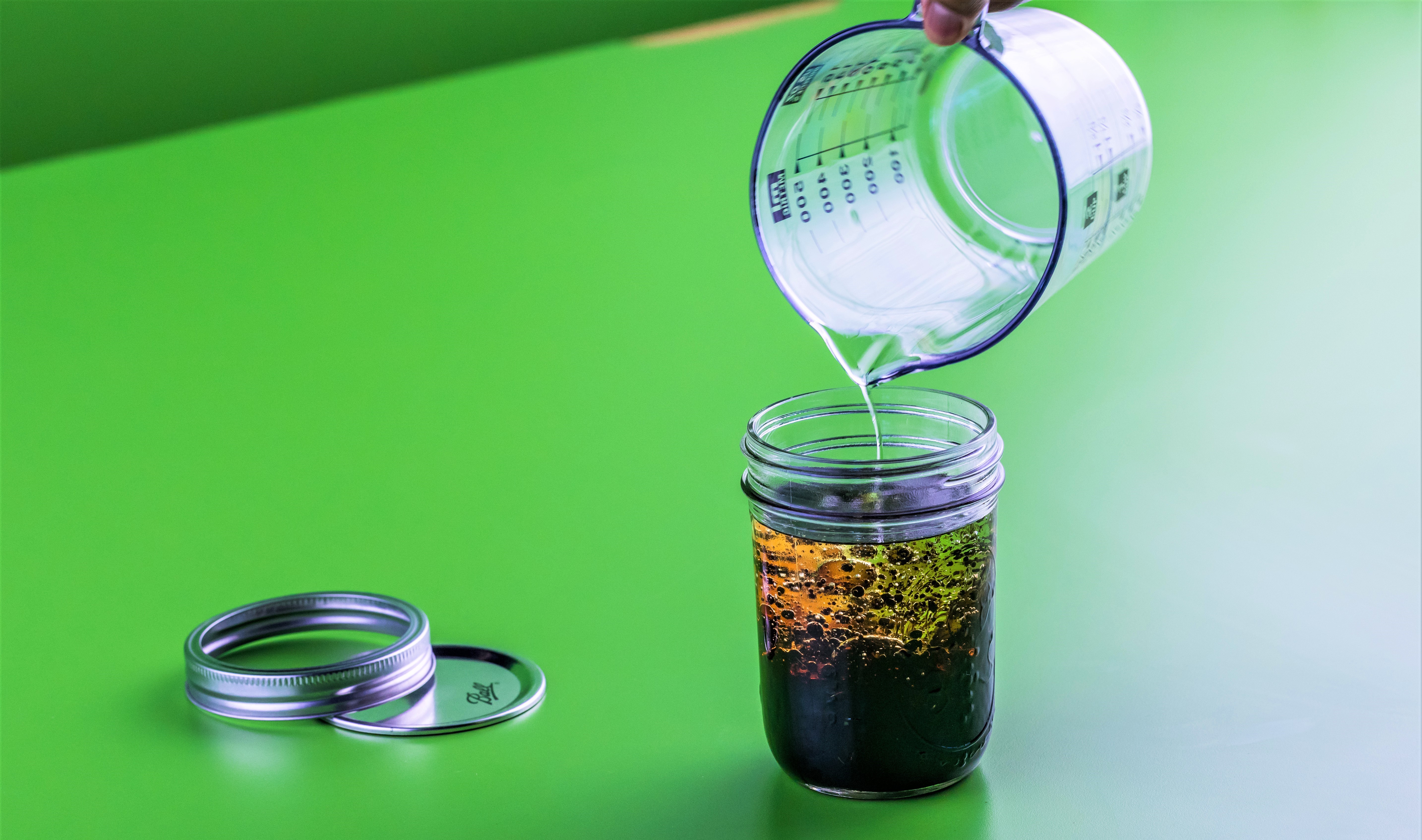 Oil pouring into glass jar