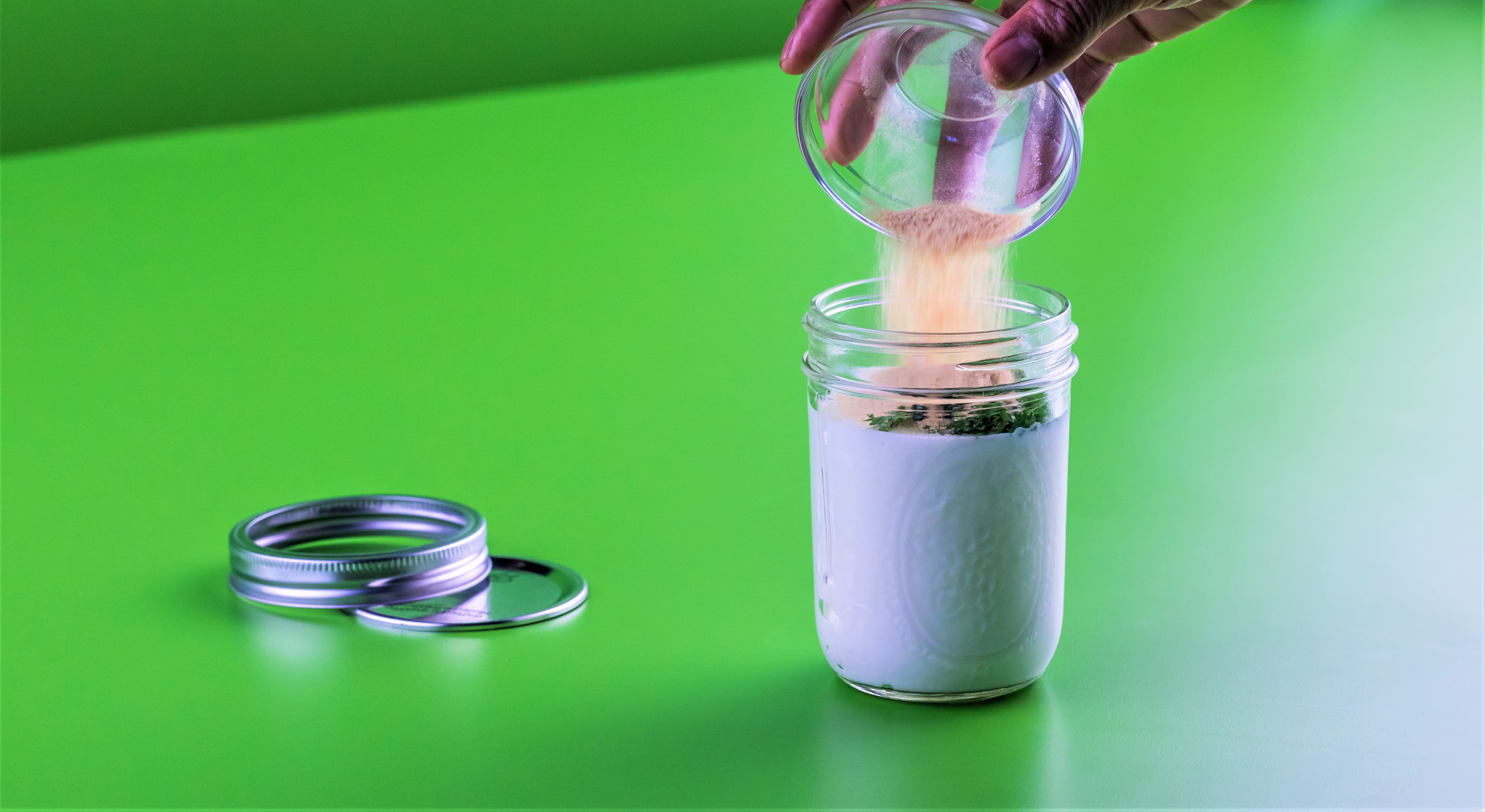 Garlic pouring into a glass jar of ranch dressing