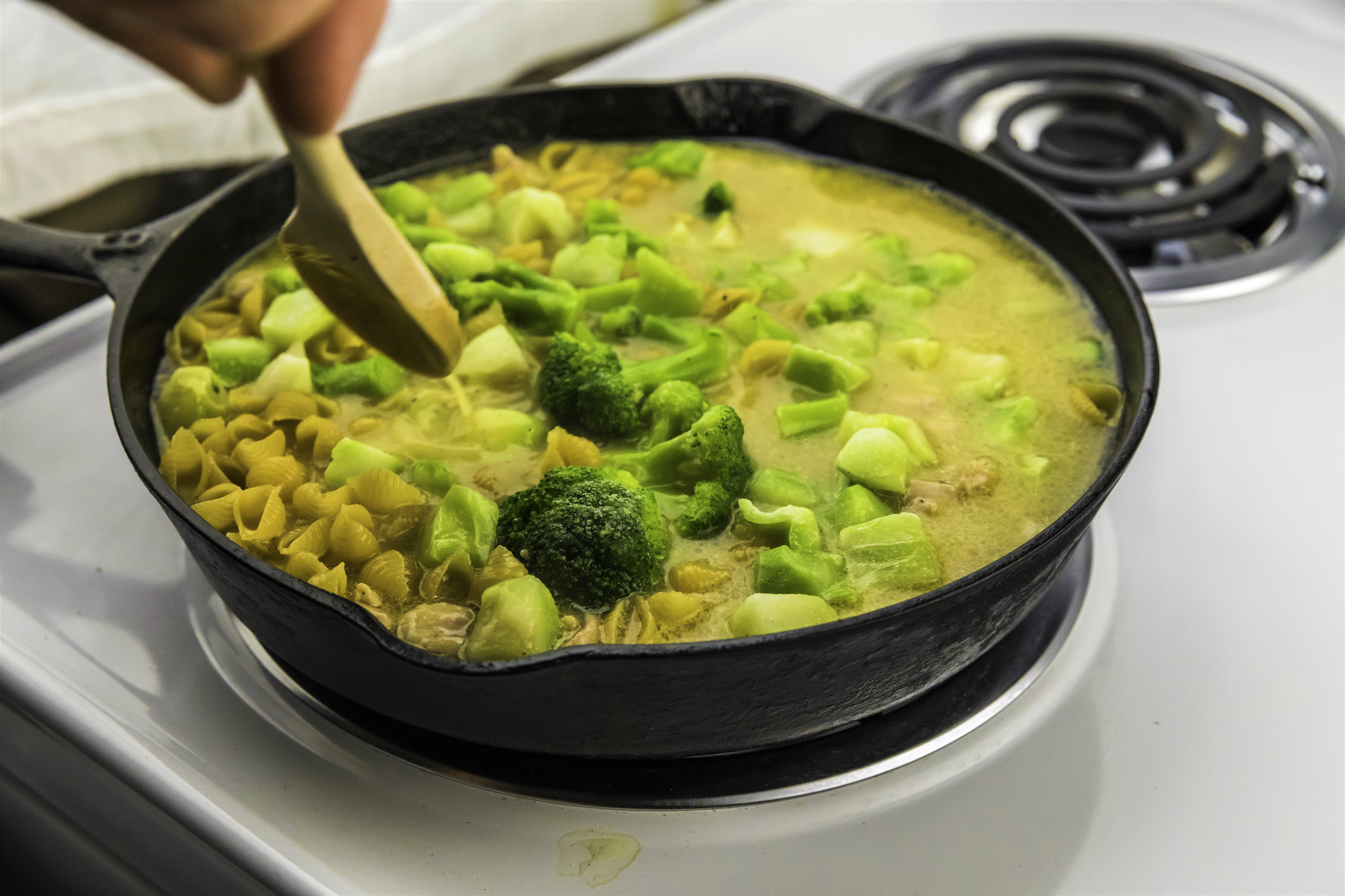 Chicken Broccoli Pasta being prepared in a skillet on the stovetop.