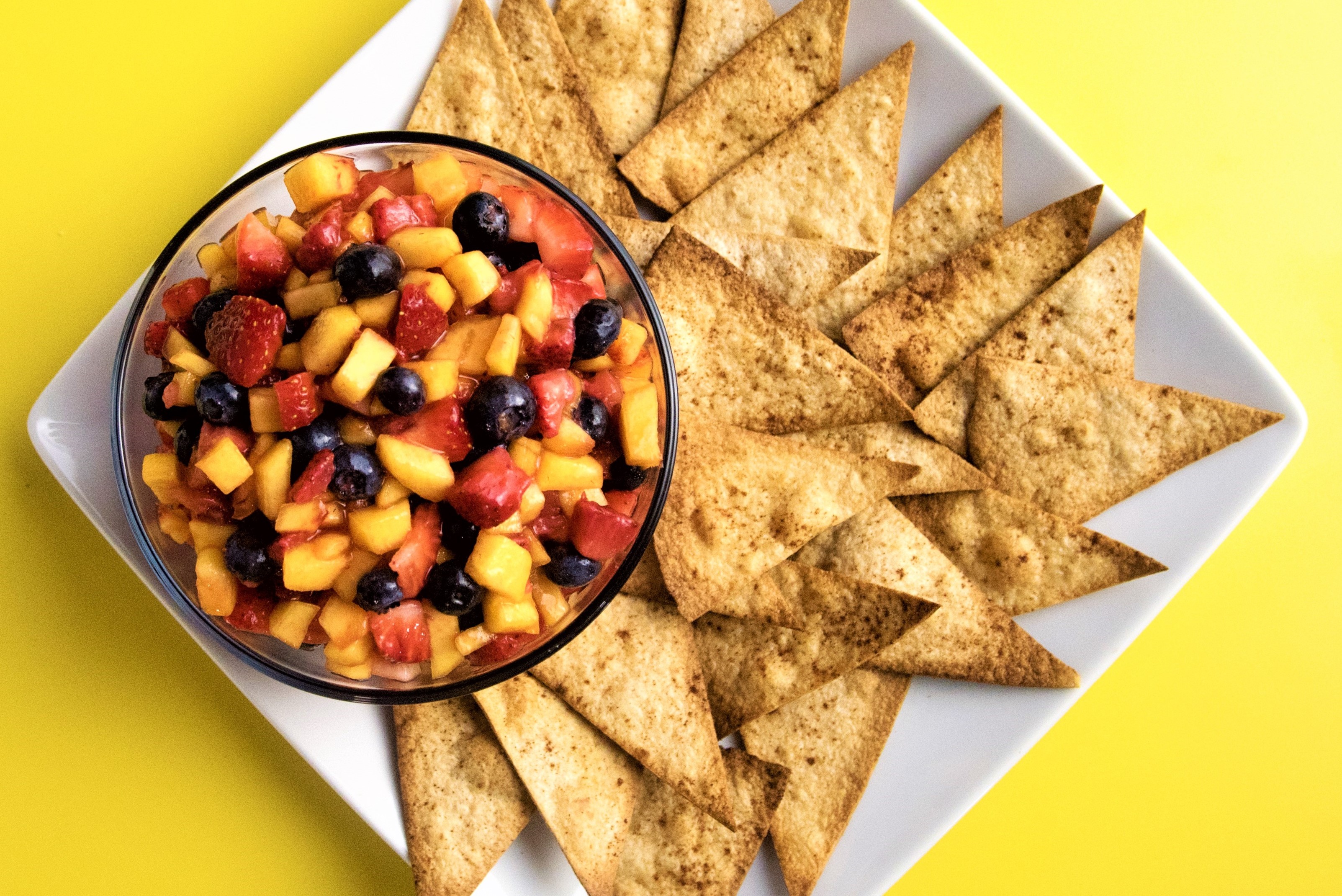 plate with tortilla chips and bowl of salsa