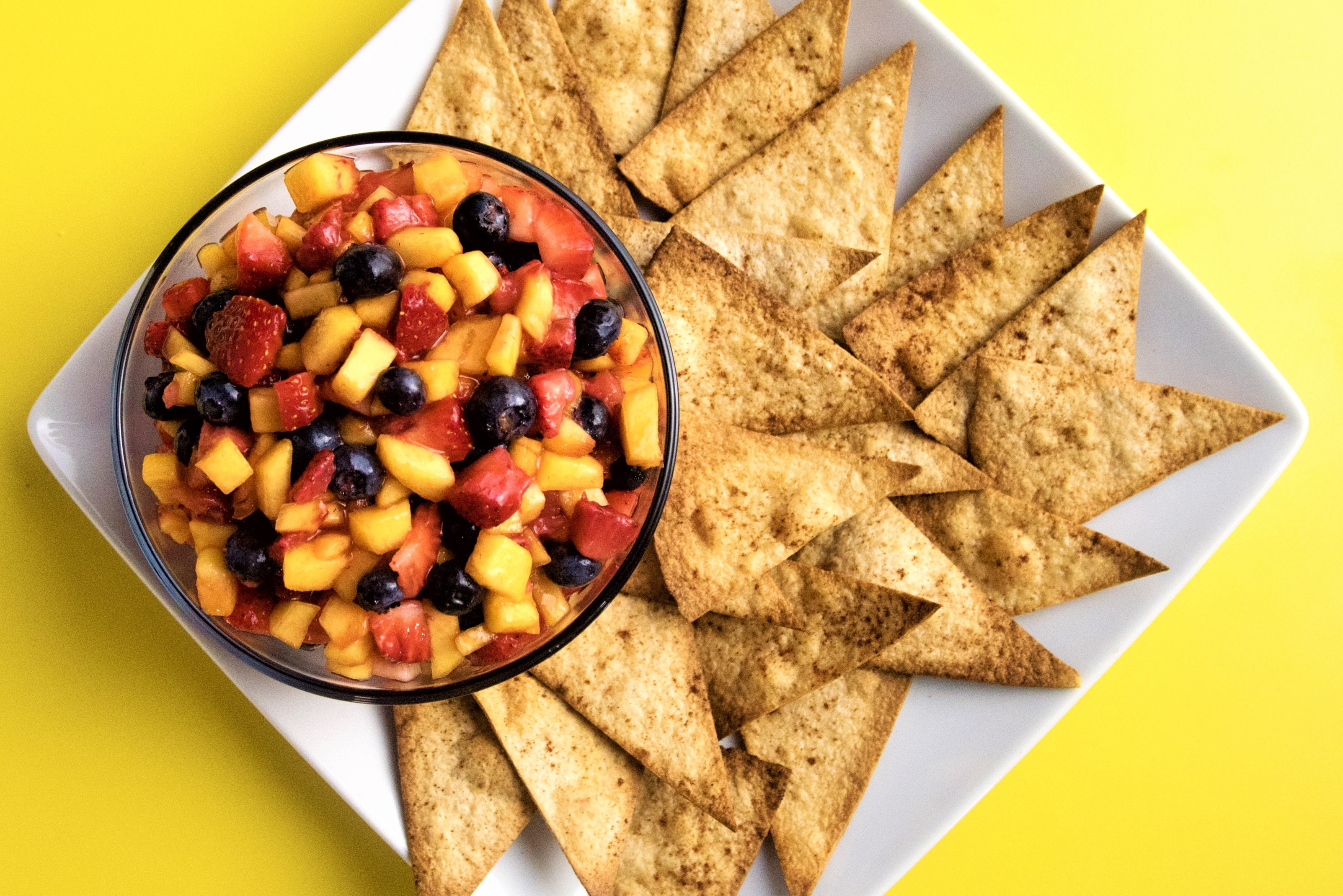 plate with bowl of fruit salsa and tortilla chips
