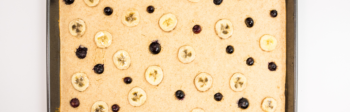 A baking sheet with blueberry and banana sheet pan pancakes