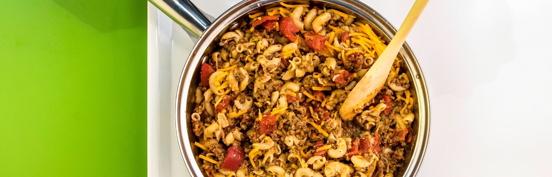 pot of beefy macroni and cheese being stirred