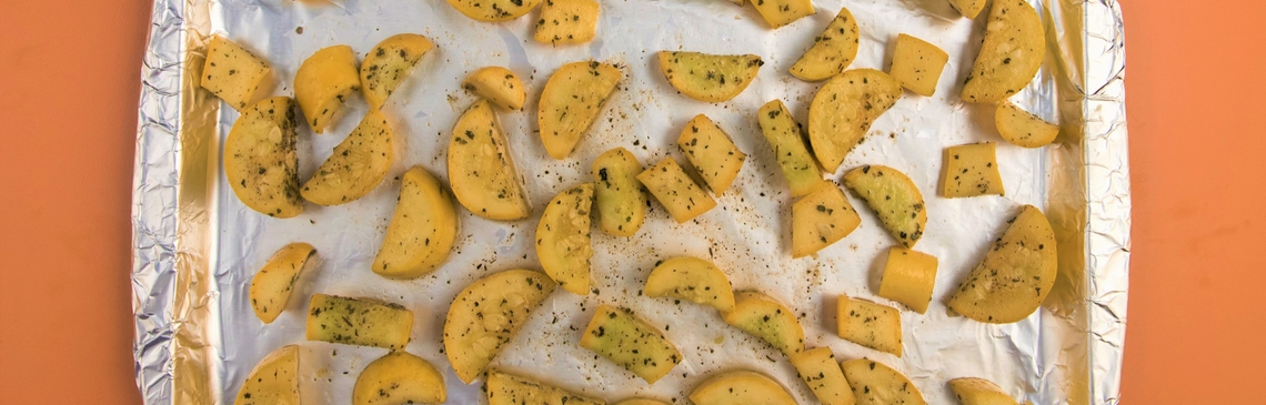 foil-covered baking sheet with salt and peppered squash slices