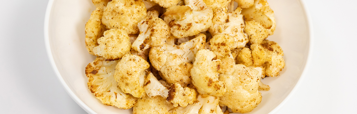 A bowl of Roasted Cauliflower on a white background