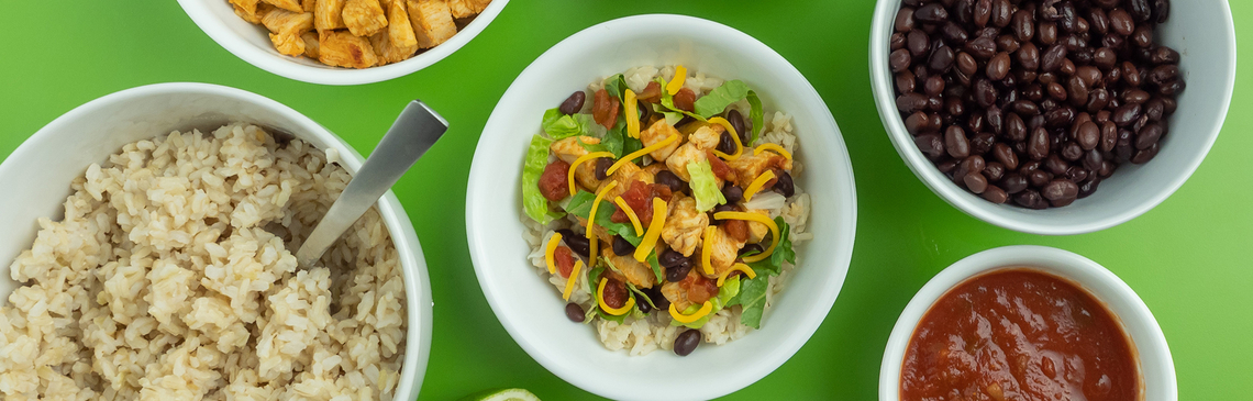 Bowls of rice, chicken, lettuce, black beans, salsa, cheese and a central Southwest bowl