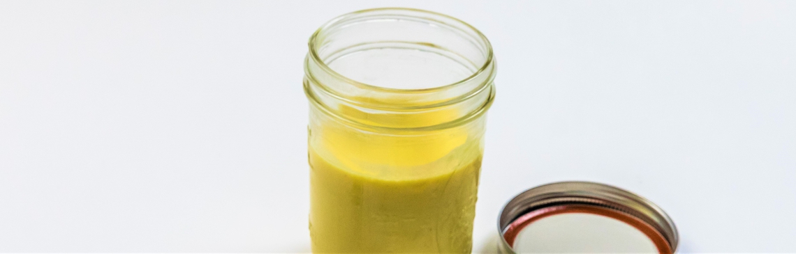 A glass jar of honey mustard dressing