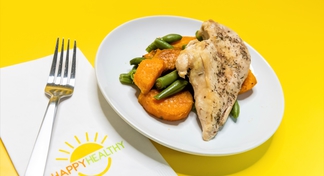 fork, napkin, and plate with a seasoned chicken filet over green beans and sweet potatoes