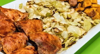 Blackened chicken, roasted cabbage, and roasted sweet potatoes on white plate with green background.