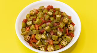 A white bowl of Tomatoes and Okra on a yellow background