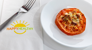 A plate with one baked tomato next to a fork and Happy Healthy napkin