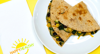  A white platter of black bean and vegetable quesadillas next to a happy healthy napkin