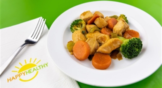 A plate of chicken stir fry next to a HappyHealthy napkin and fork