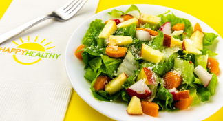 Chopped salad next to white HappyHealthy napkin with fork. 