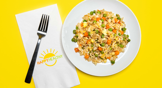 A plate of fried rice next to a fork and HappyHealthy napkin