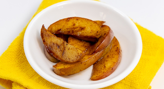 A bowl of Hot Cinnamon Apples on a yellow napkin