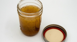 italian dressing in a glass jar with lid to the right.