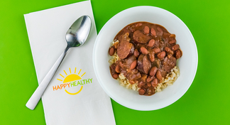 Slow Cooker Red Beans and Rice in a bowl with a spoon on a HappyHealthy napkin.