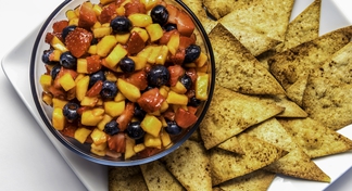 plate with tortilla chips and bowl of fruit salsa