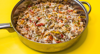 A pan of Beef and Pepper Skillet on a yellow background