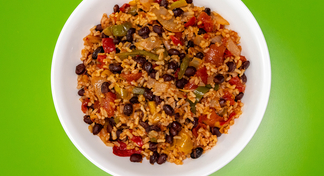 A white bowl of Black Beans and Rice on a green background