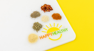 A white happy healthy cutting board with cajun seasoning spices on a yellow background