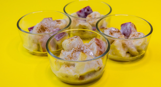 4 glasses filled with chilled banana salad on a yellow background