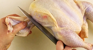A whole chicken being cut into 8 pieces