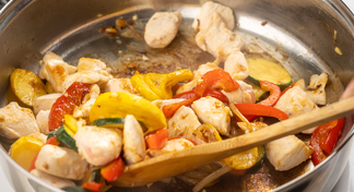 A sauté pan with chicken and veggies stir fry