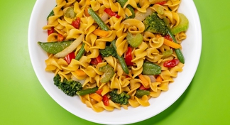 A plate of pasta with stir fried vegetables