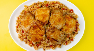 a plate of Pork Chops over Vegetable Rice