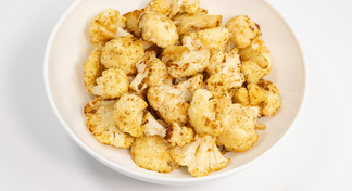 A bowl of Roasted Cauliflower on a white background