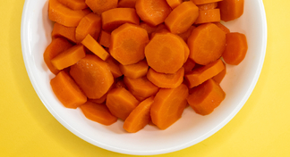 A white bowl filled with sautéed carrots