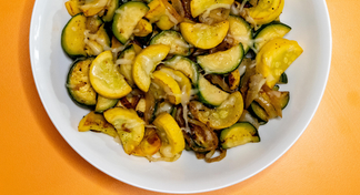 A white plate with sauteed squash