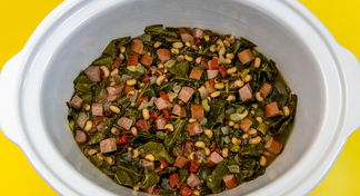 A crockpot of Slow Cooker Sausage, Greens, and Black-eyed Peas on a yellow background