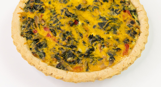 A vegetable quiche on a white background