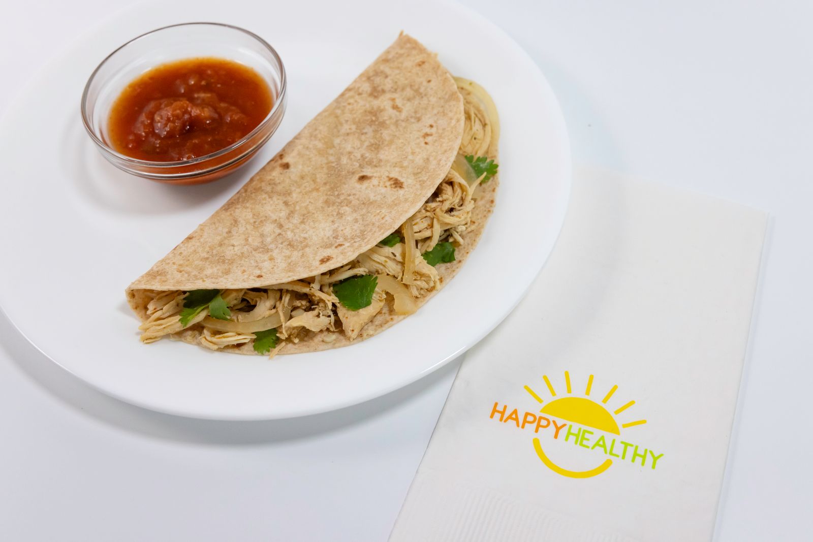 A plate of with a Salsa Verde Chicken quesadilla and salsa