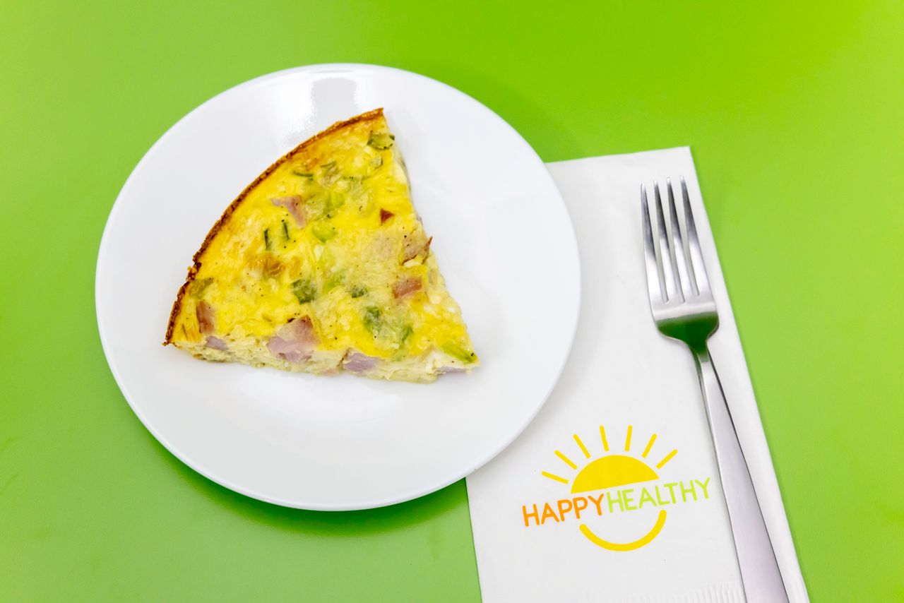 A plate with a wedge of Crustless Ham and Cheese Quiche