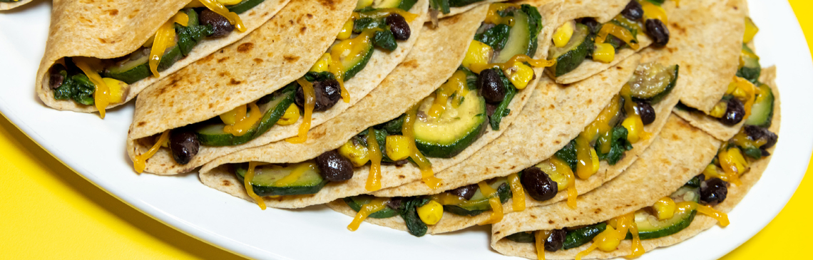 A white platter of black bean and vegetable quesadillas