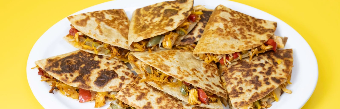 A white plate filled with Chicken Quesadillas