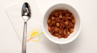  spoon, napkin, and bowl of chickpeas and tomatoes