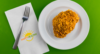 Plate with 1 piece of fried chicken beside a napkin and fork.